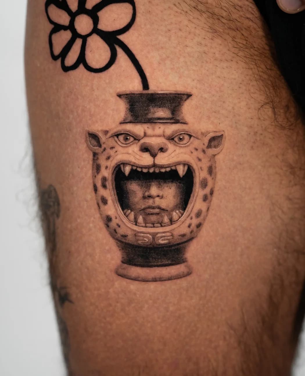 Jaguar-headed vessel with a single flower stem