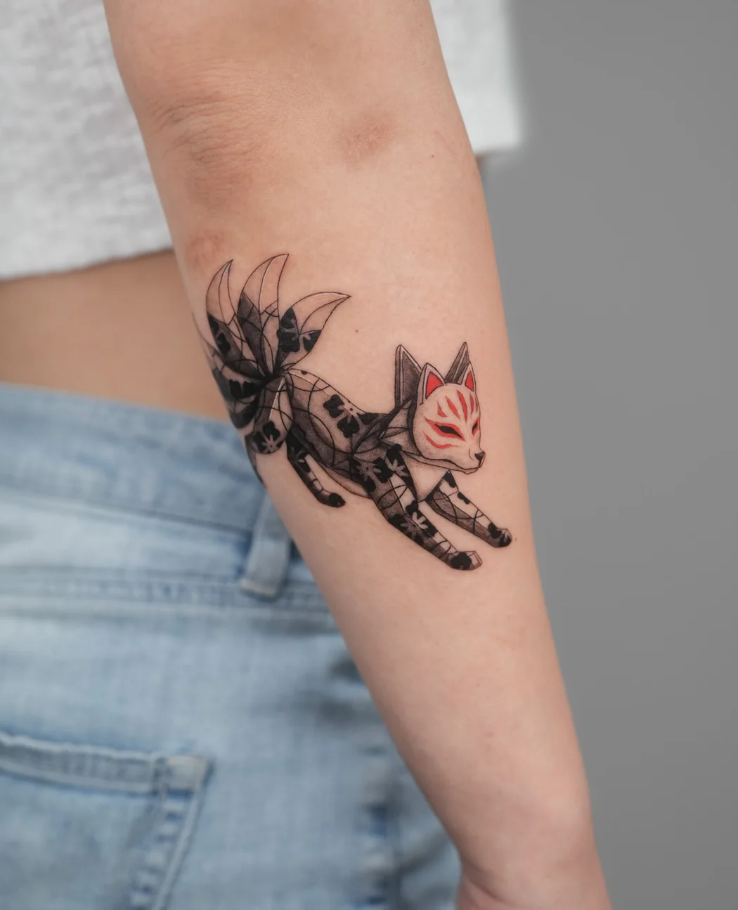 Origami kitsune fox running along a forearm