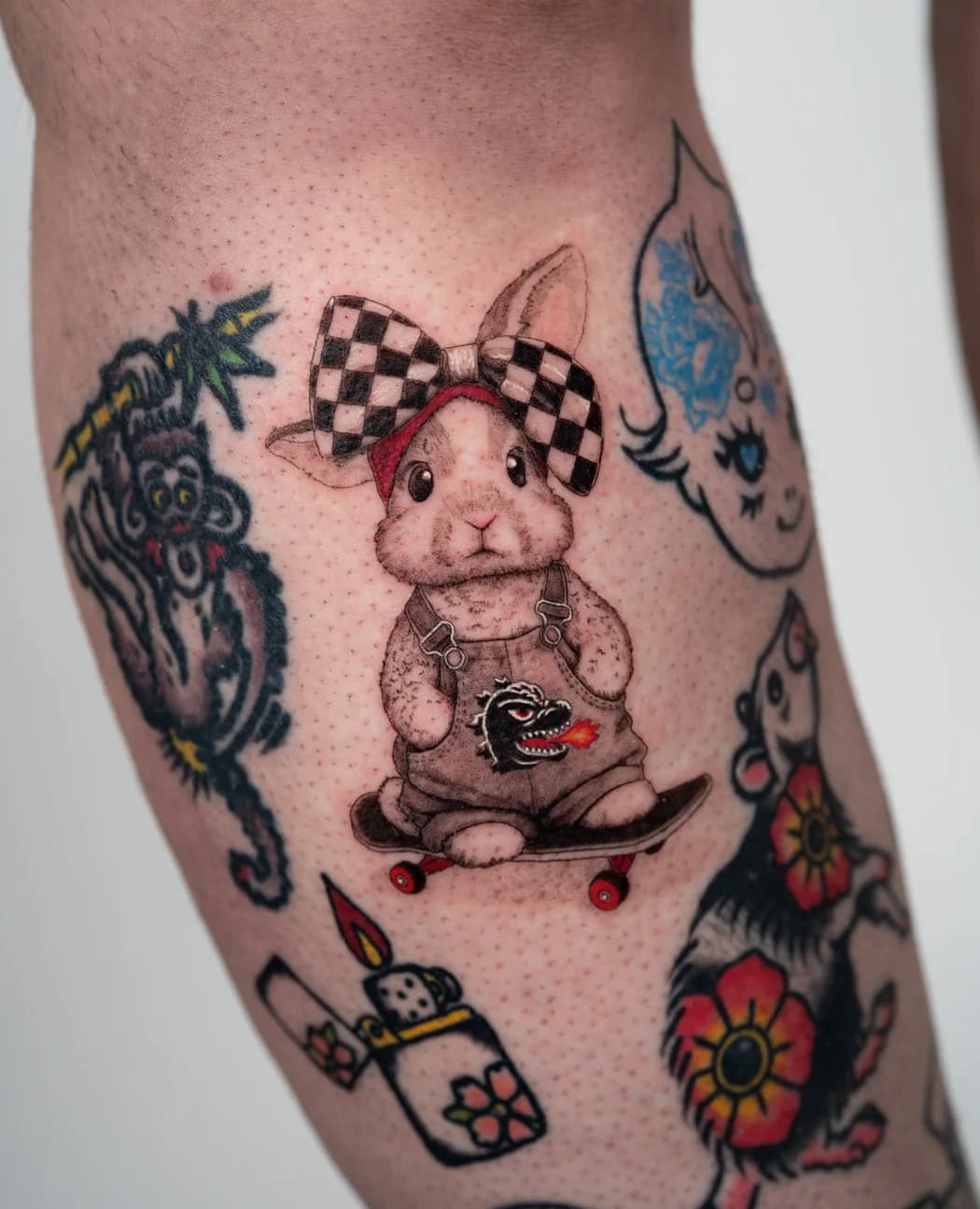 Rabbit on a skateboard among older tattoos, in colour