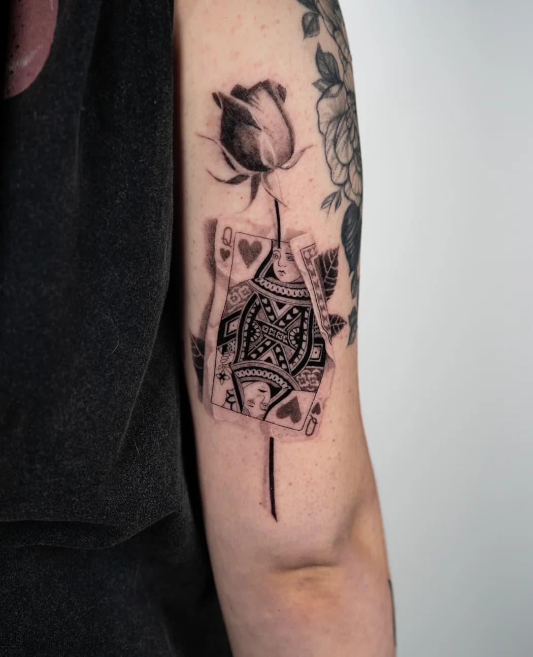 Rose above a queen of hearts playing card
